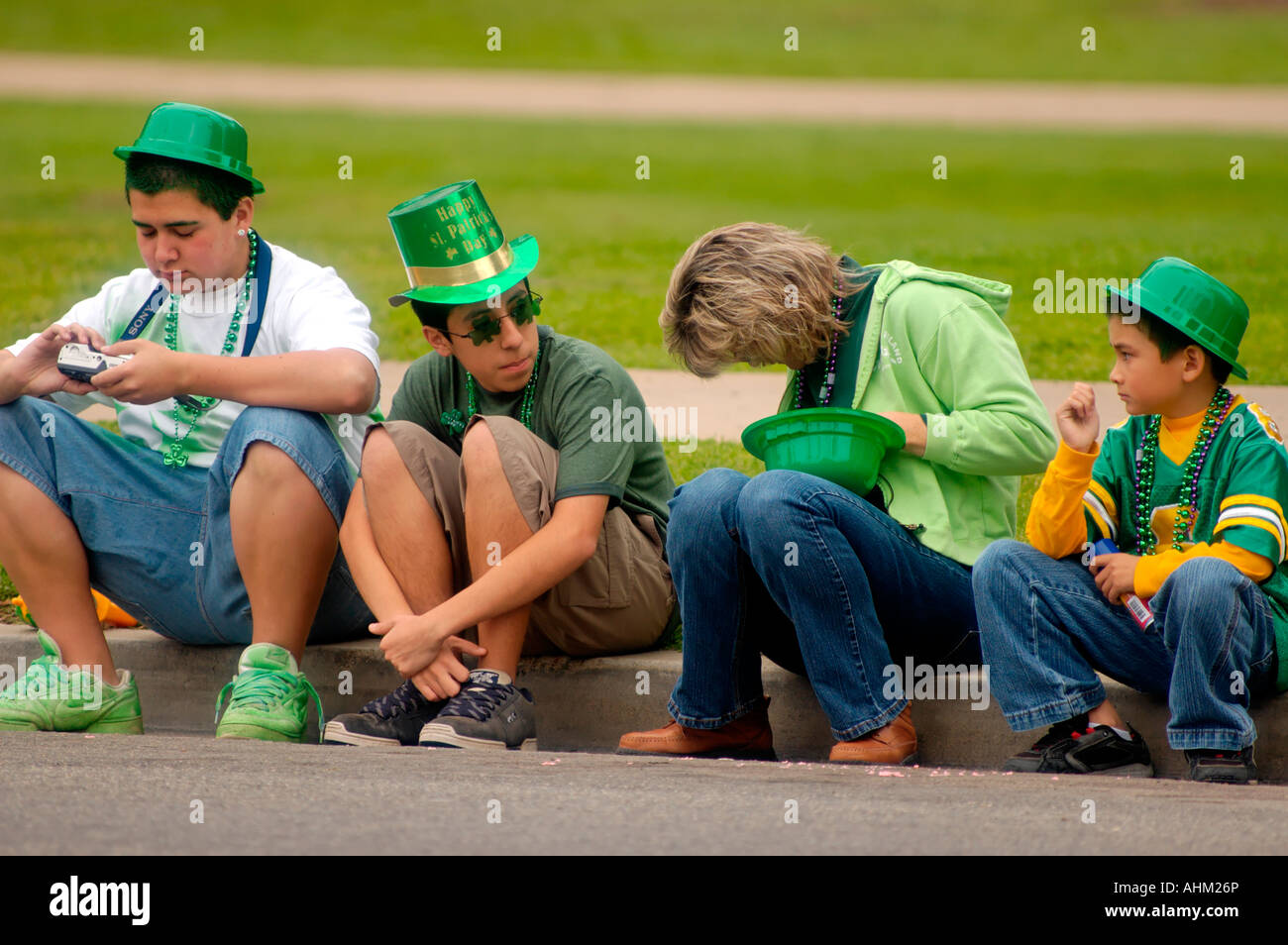 Caucasian family with green hats sitting on the curb at St.Patrick's