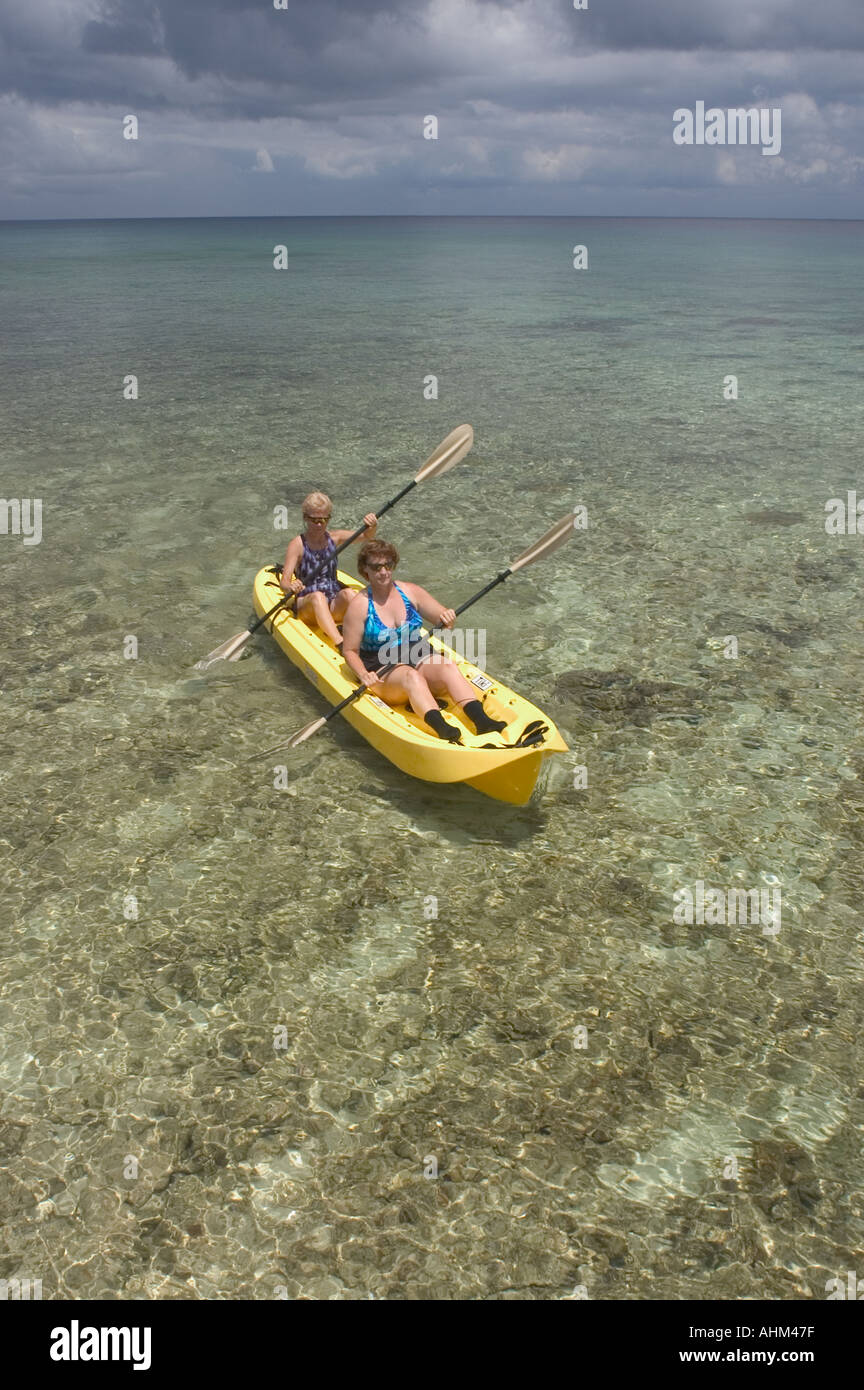 Two women paddling a kayak over a shallow reef in Cayman Brac Cayman