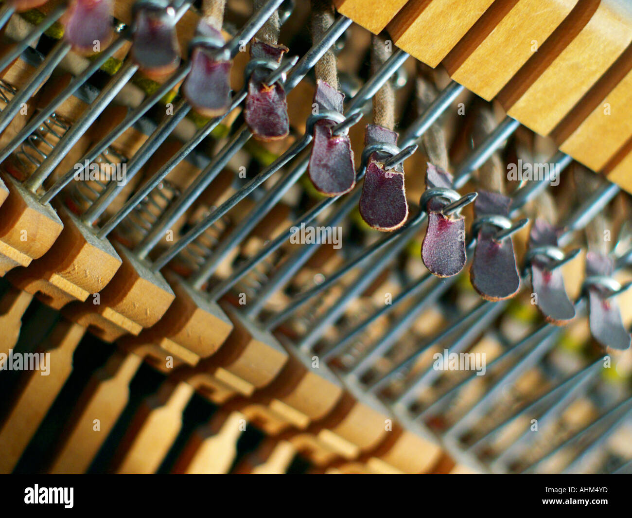 Wood, wire, and leather mallet linkages inside a piano's soundbox that enable the striking of strings Stock Photo