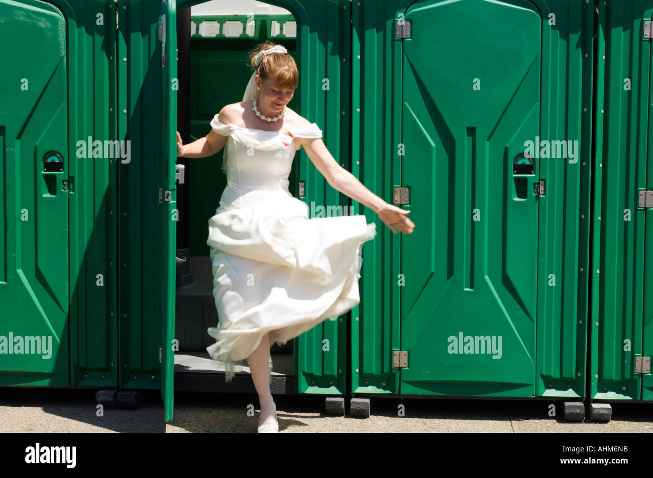 Bride stepping out of a portableble lavatory loo Stock Photo