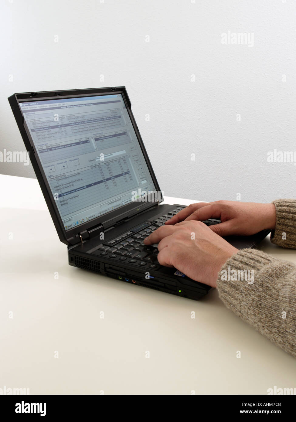 Hands of a man typing on a IBM laptop computer with office software on screen Stock Photo