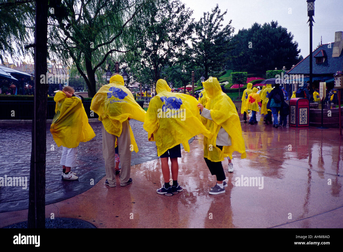 A family put on their rain capes at Euro Disney Paris as it starts to rain France Europe Stock Photo - Alamy