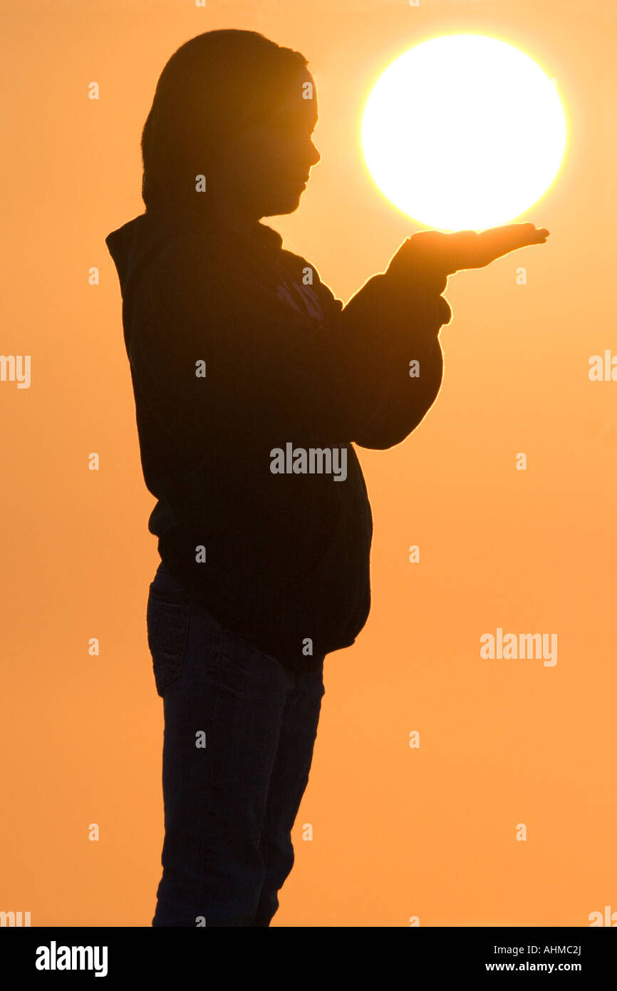 Young Girl holding the morning Sun in her hands Stock Photo - Alamy