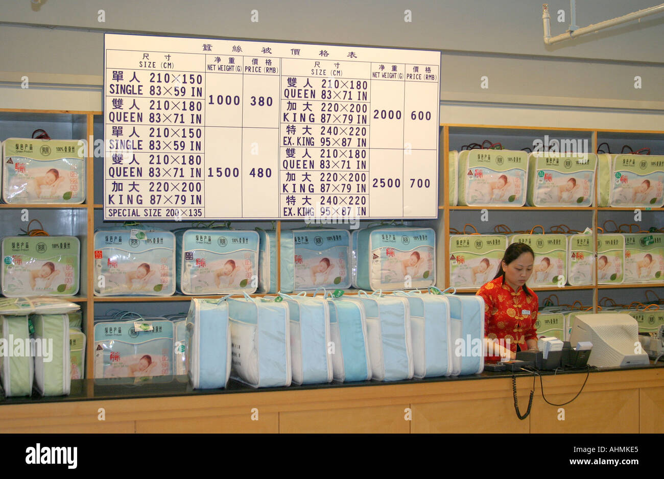 Sales woman at counter in a silk shop in Shanghai Stock Photo