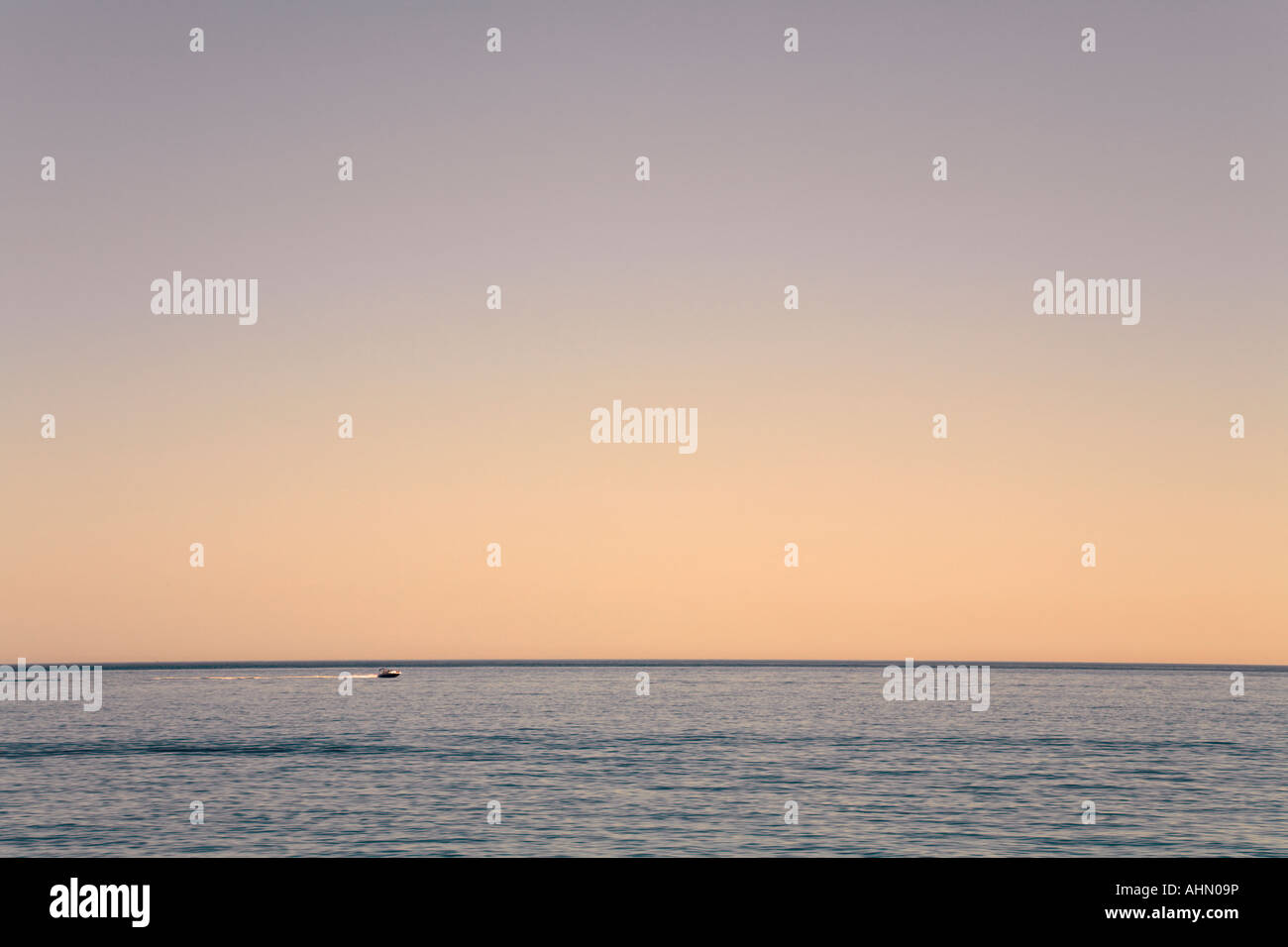 Boat speeding across empty ocean Stock Photo - Alamy