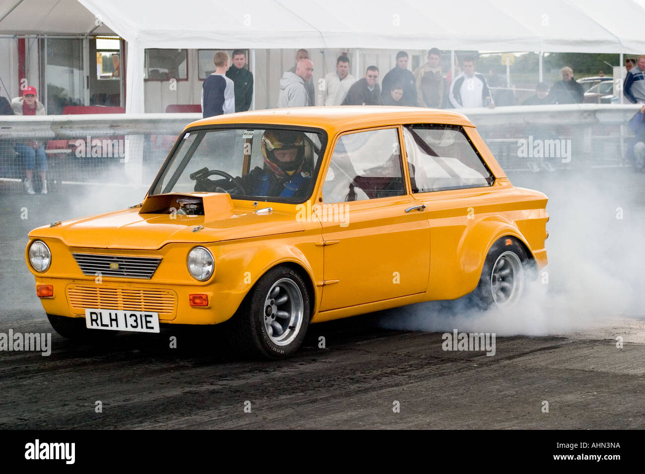 Heavily modified Hillman Imp doing a burnout prior to drag race Stock Photo