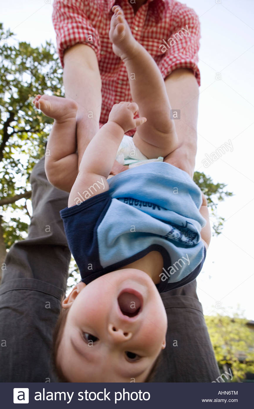 Parent holding baby upside down Stock Photo: 14512579 - Alamy