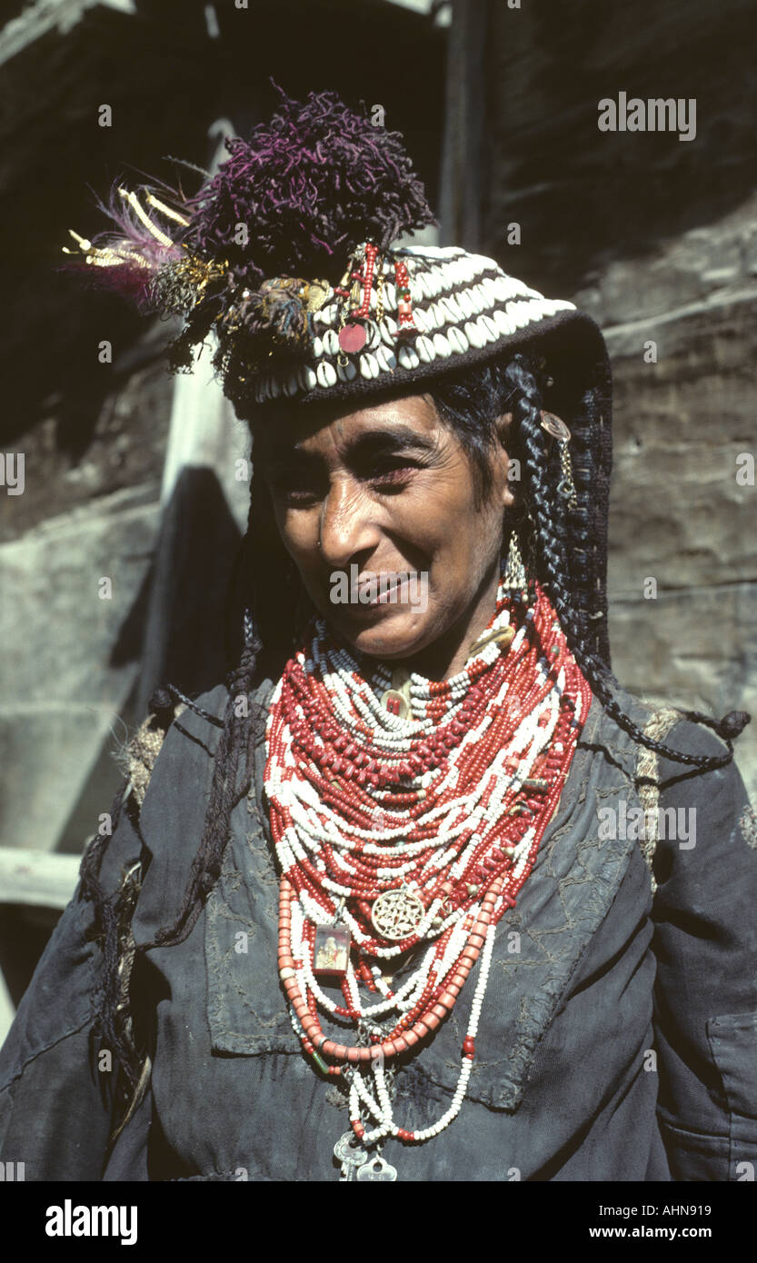 Kalash tribal woman wearing beads and ornate outer headdress decorated with beads cowrie shells pom poms and bright metal parts Stock Photo