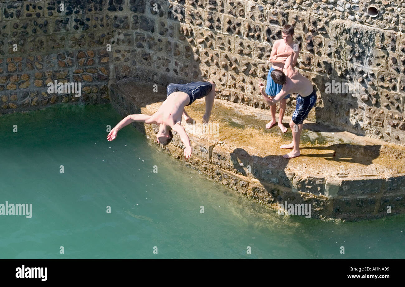 Teenage Boys Jumping Off Groyne Into The Sea Brighton England