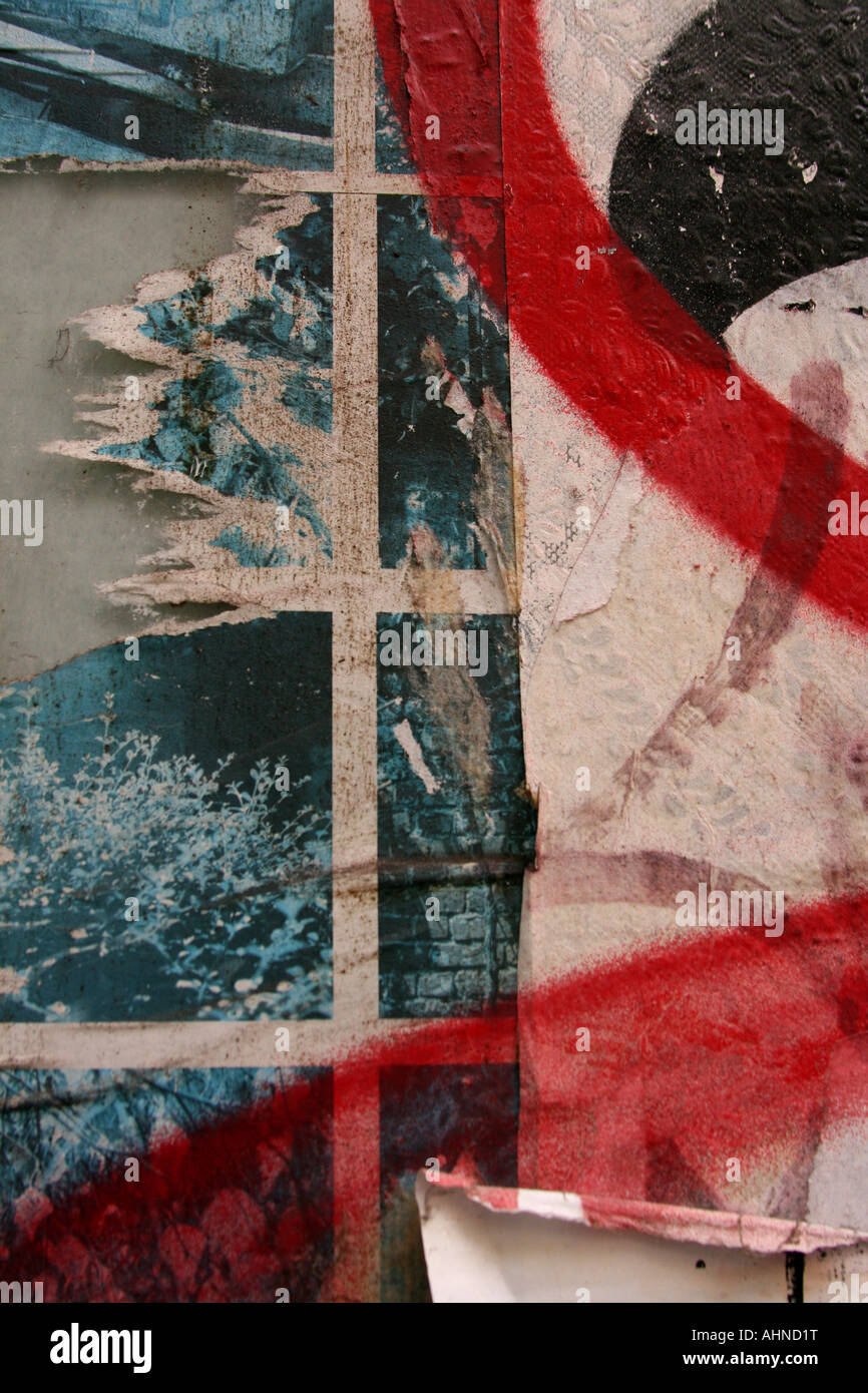 Torn poster with red spray paint graffiti Stock Photo - Alamy