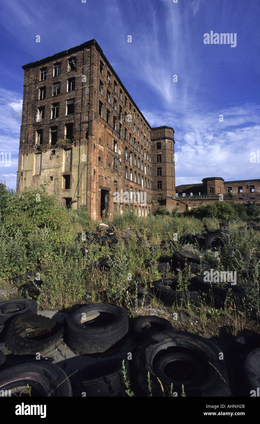 dumped car tyres outside derelict mill building in the city of leeds