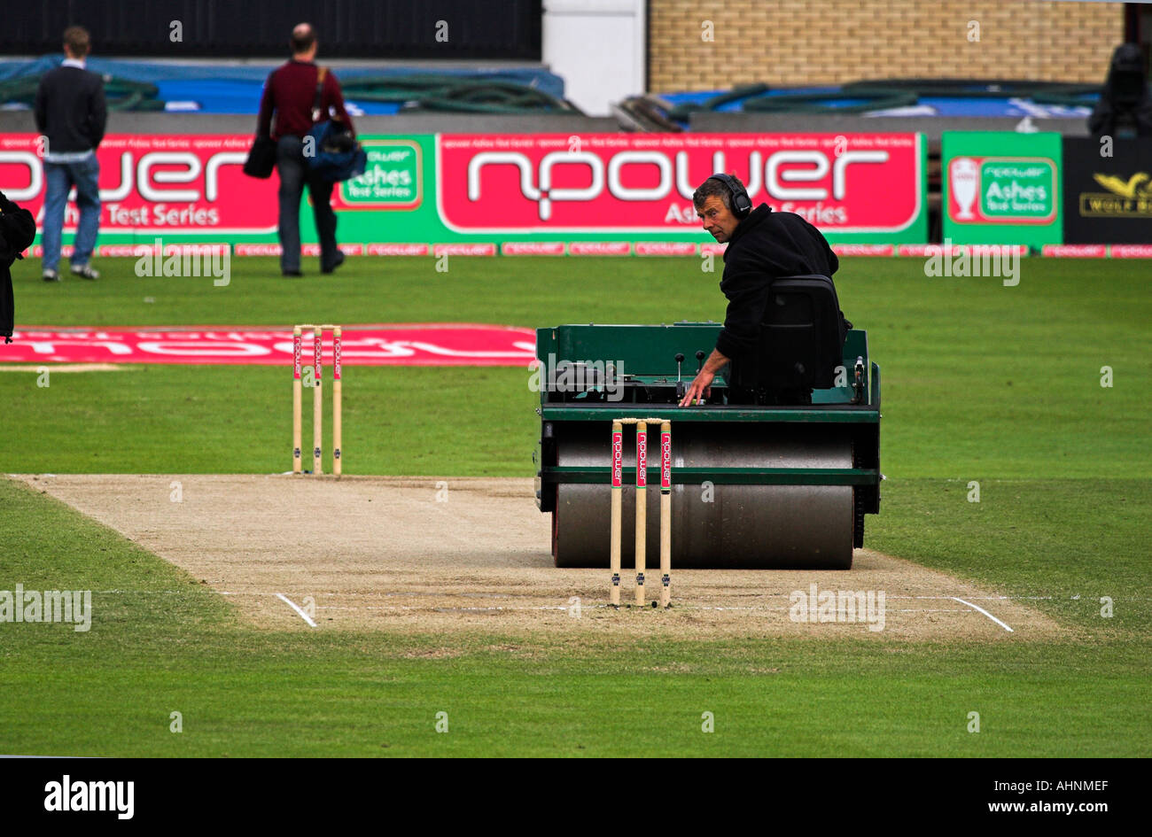Man rolling the cricket pitch in preparation for a game, England Stock Photo