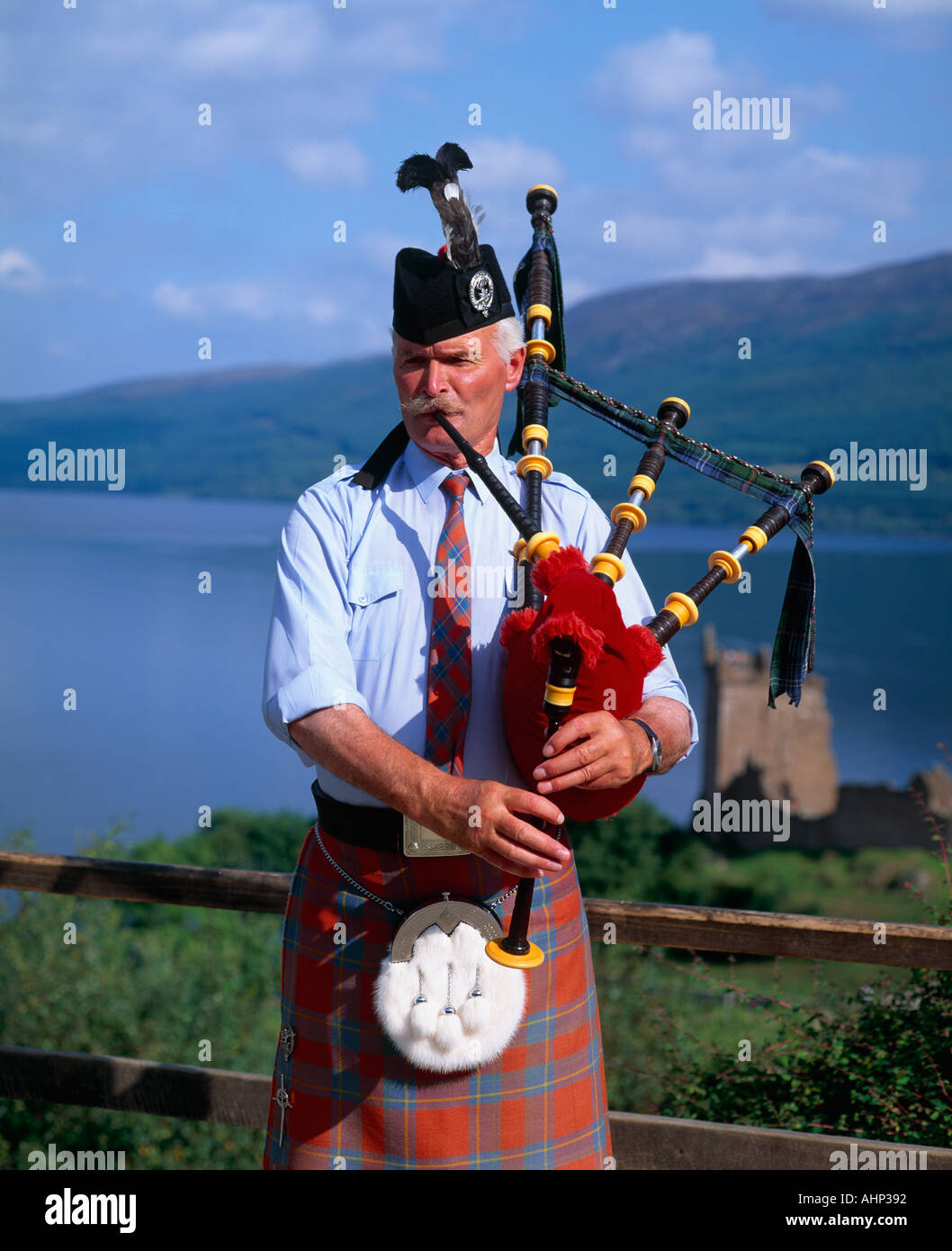 Man playing the Bagpipes at Urquhart Castle Stock Photo