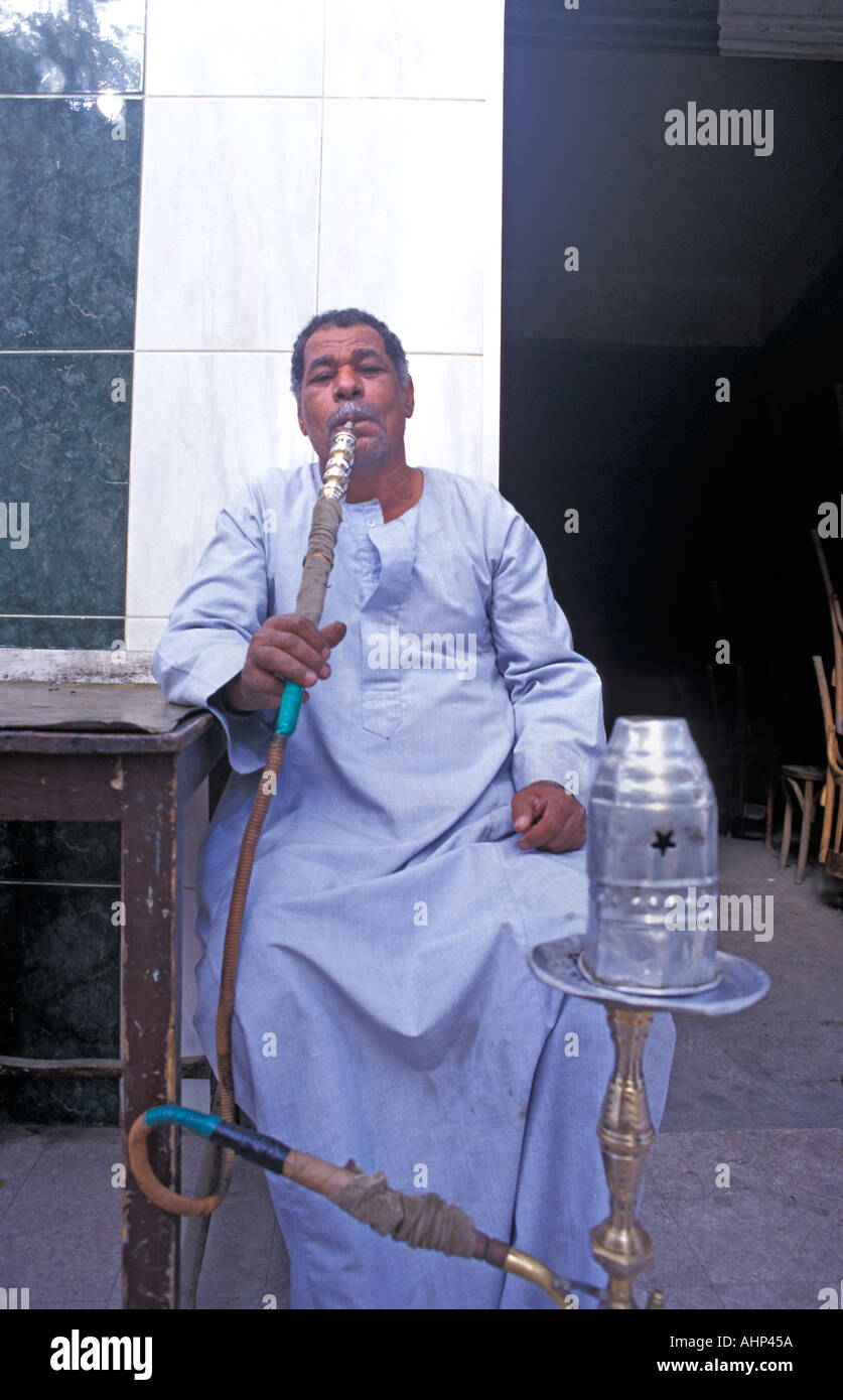 Muslim man outside a tea house in central Luxor smoking a huqqah Egypt Stock Photo