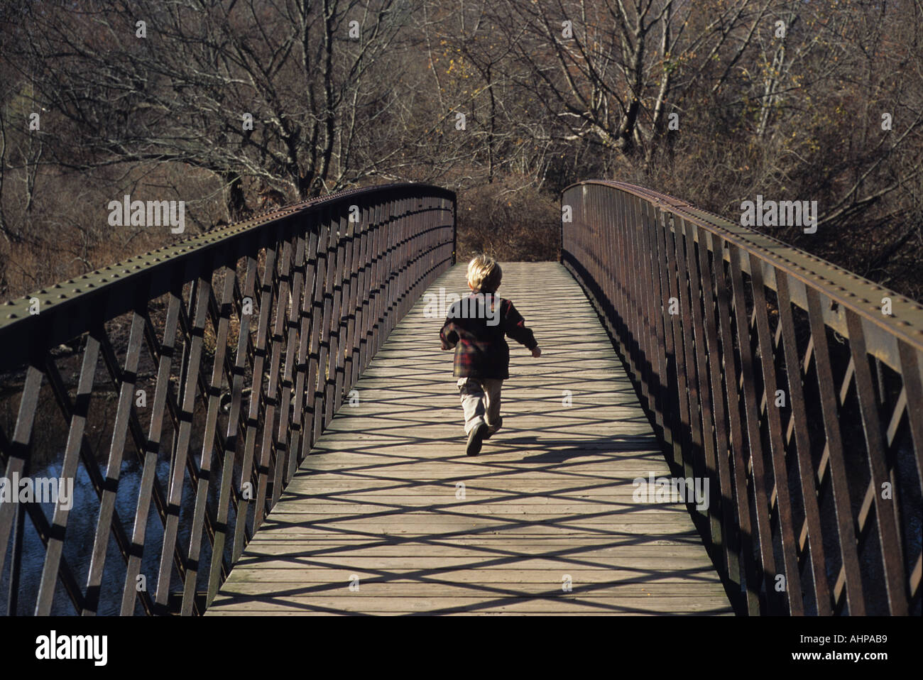 Boy running across bridge Stock Photo Alamy