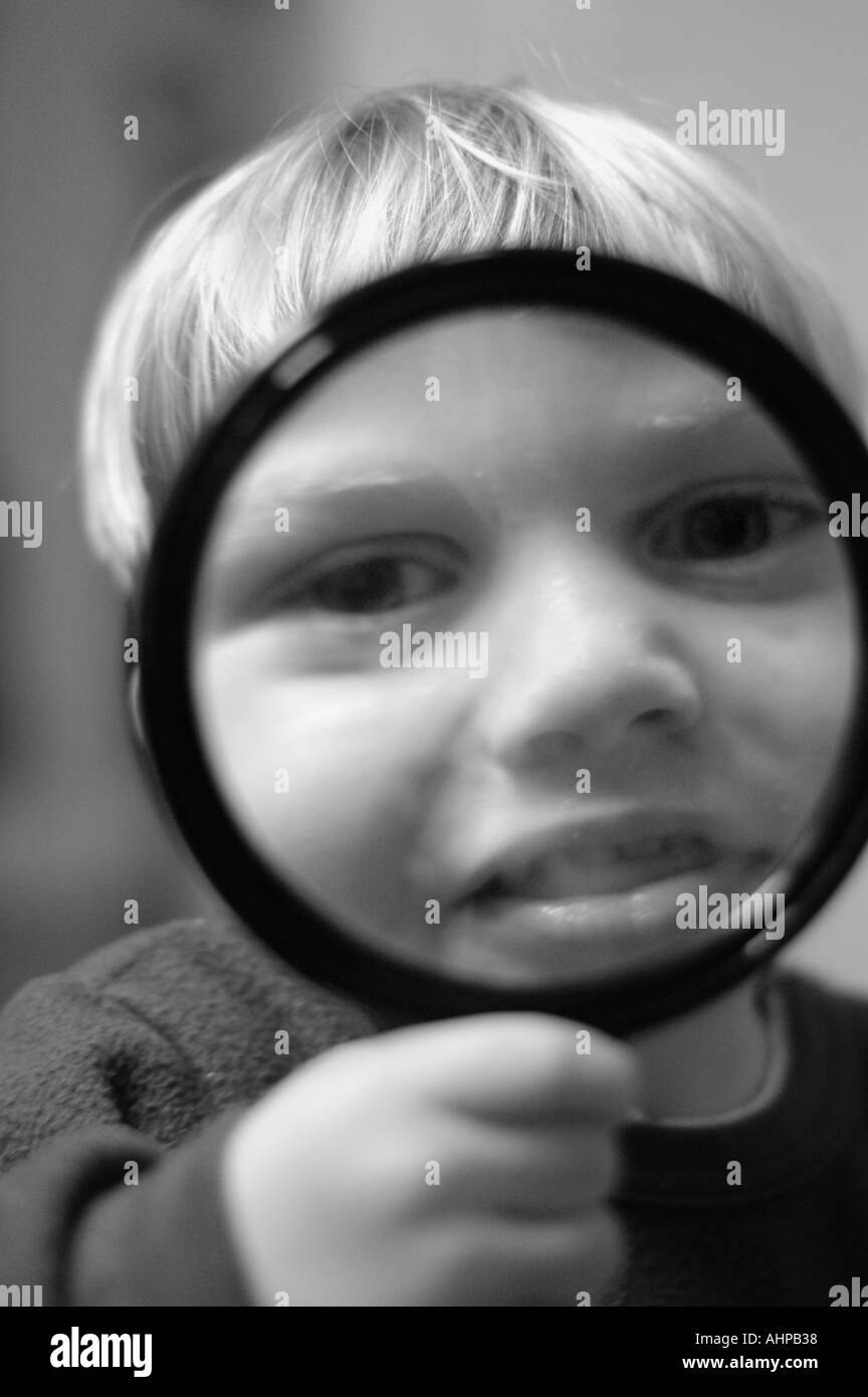 Child exploring using holding magnifying glass Stock Photo - Alamy