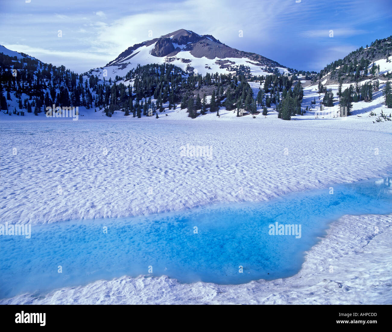 Azure water on shore of thawing Lake Helen with Mount Lassen California