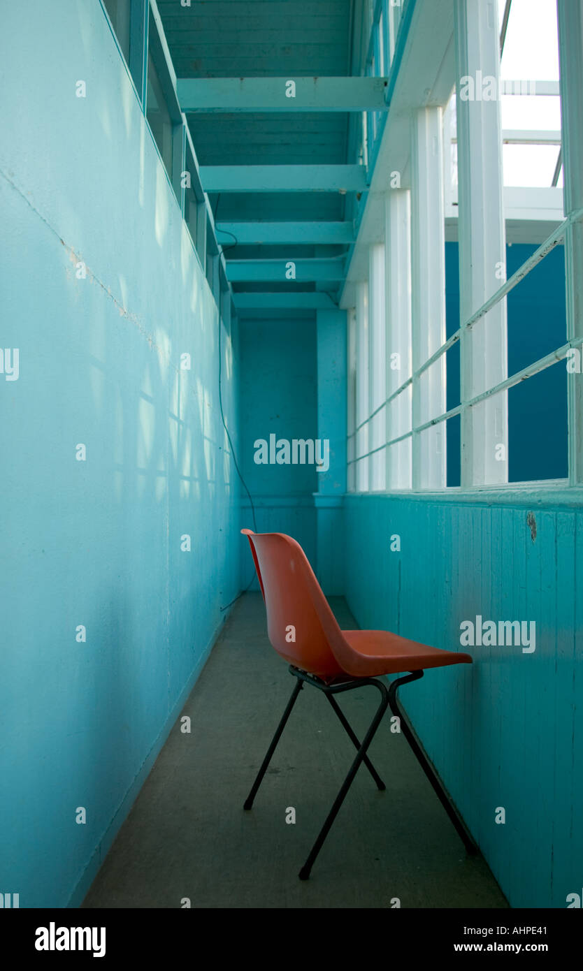 Institutionalised Red plastic chair Stock Photo