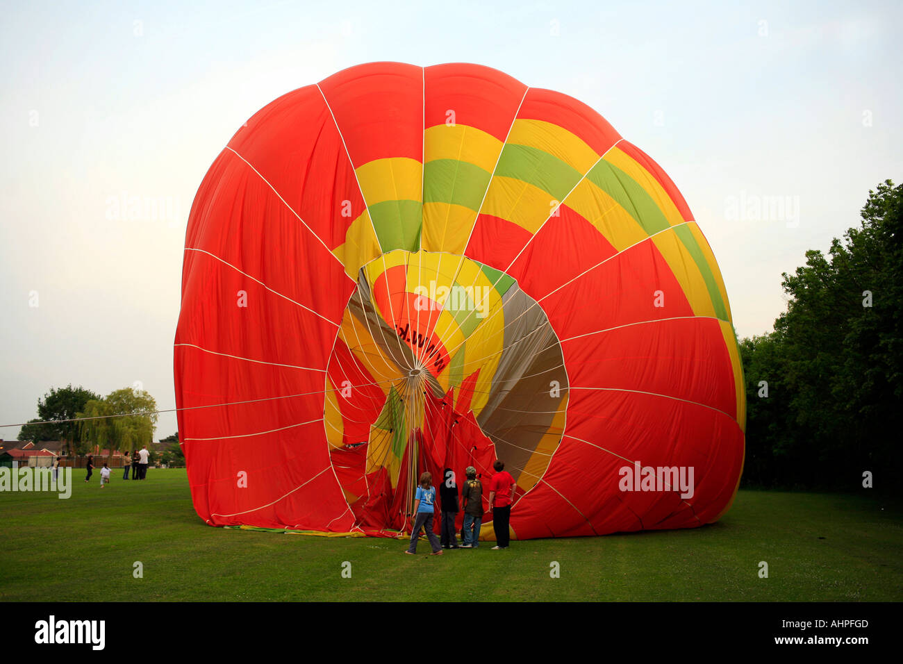 People looking inside a hot air balloon deflating after landing in a