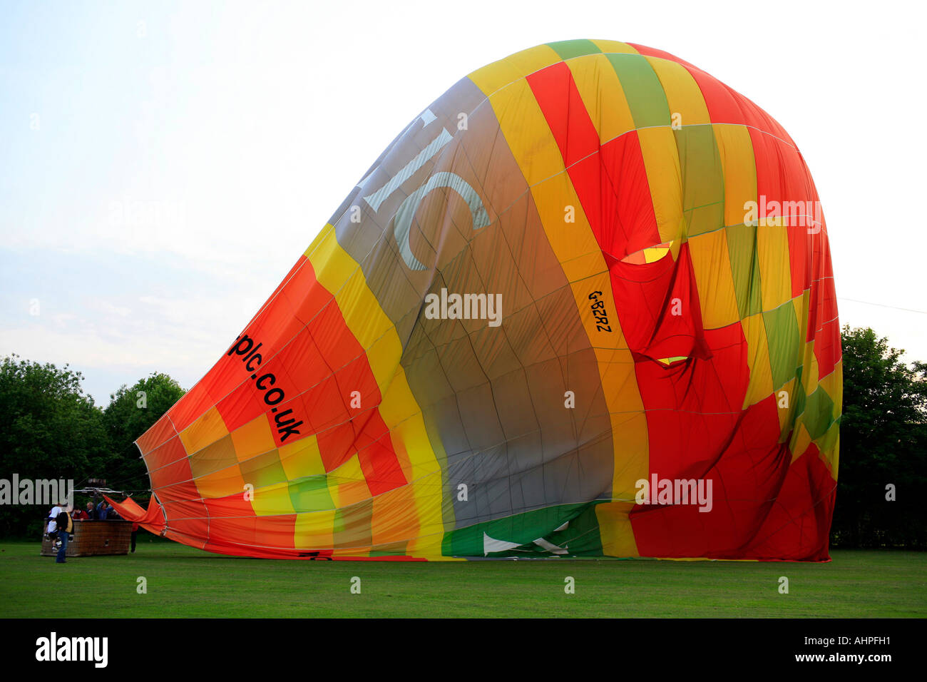 A hot air balloon deflating after landing in a field in Cheshire Stock