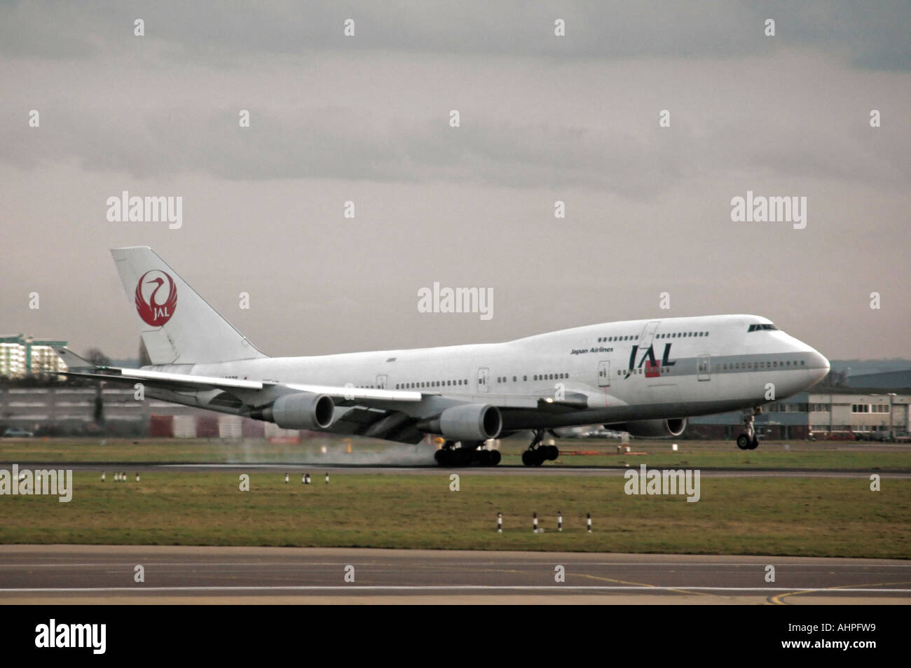 Horizontal view of a Japanese Airline (JAL) Boeing 747 at the moment of impact landing on a runway. Stock Photo