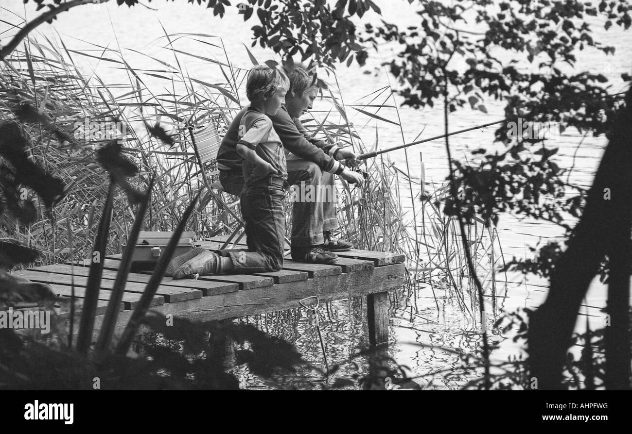 Two boys fishing Black and White Stock Photos & Images - Alamy