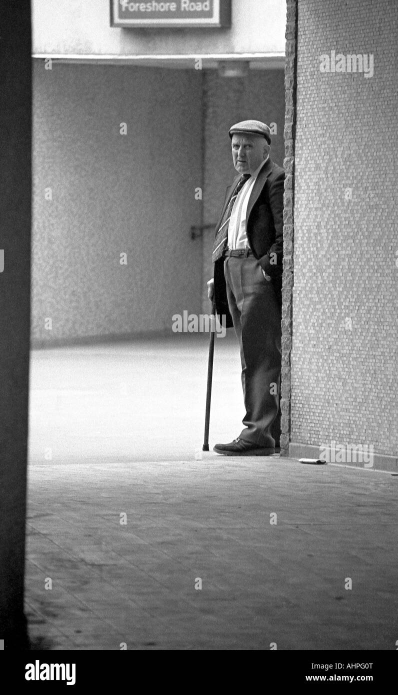 Old man with walking stick on his own in an alley. Stock Photo