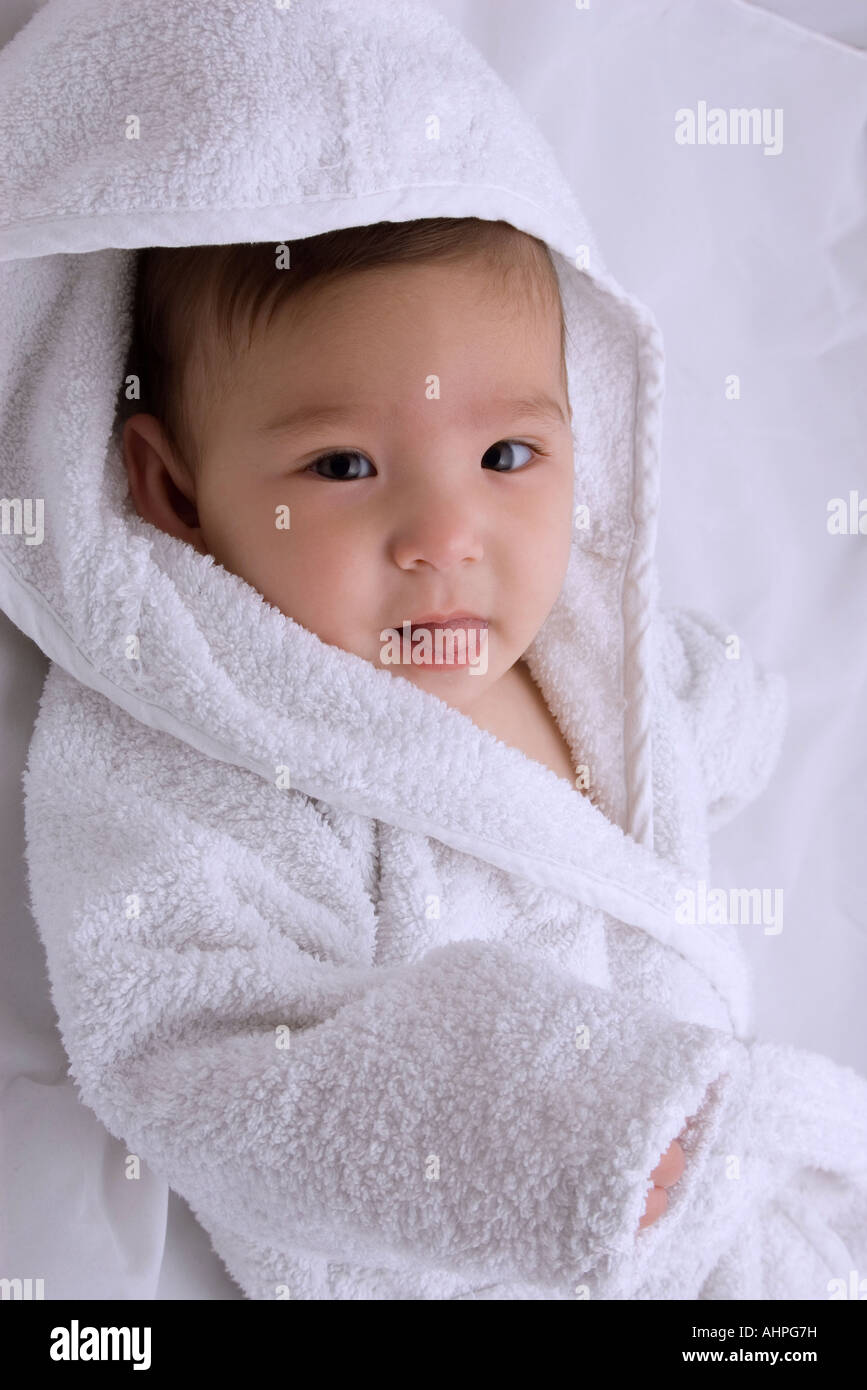 A baby looking cute in a white soft bath towel after the bath Stock