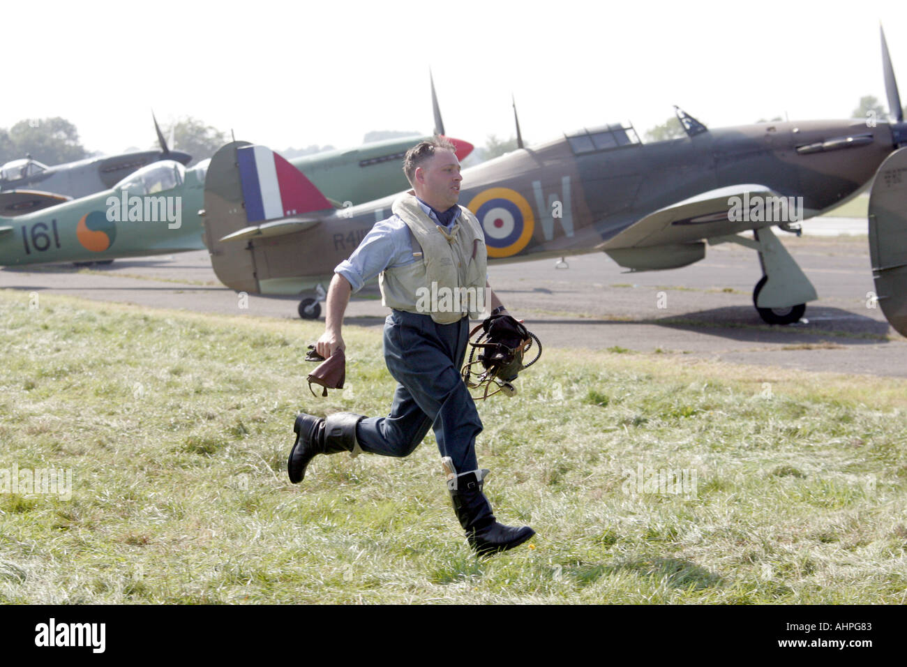 RAF at War pilot in period costume runs to a Spitfire during a WW2 Scramble re anactment living history Stock Photo