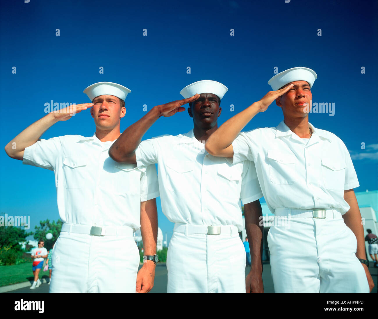 Ethnically diverse trio of sailors saluting Stock Photo