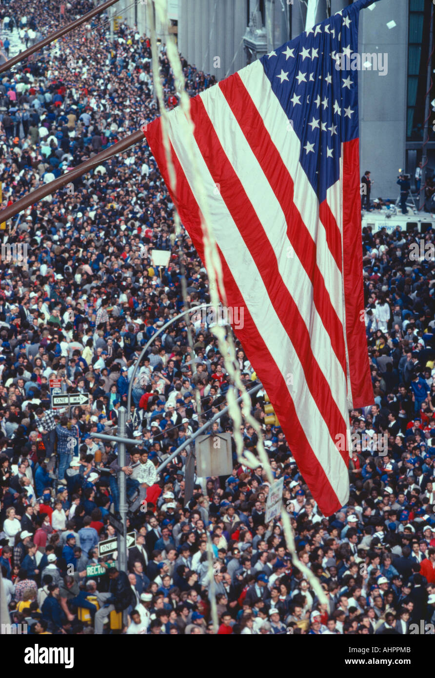American flag flying over large crowd at tickertape parade New York