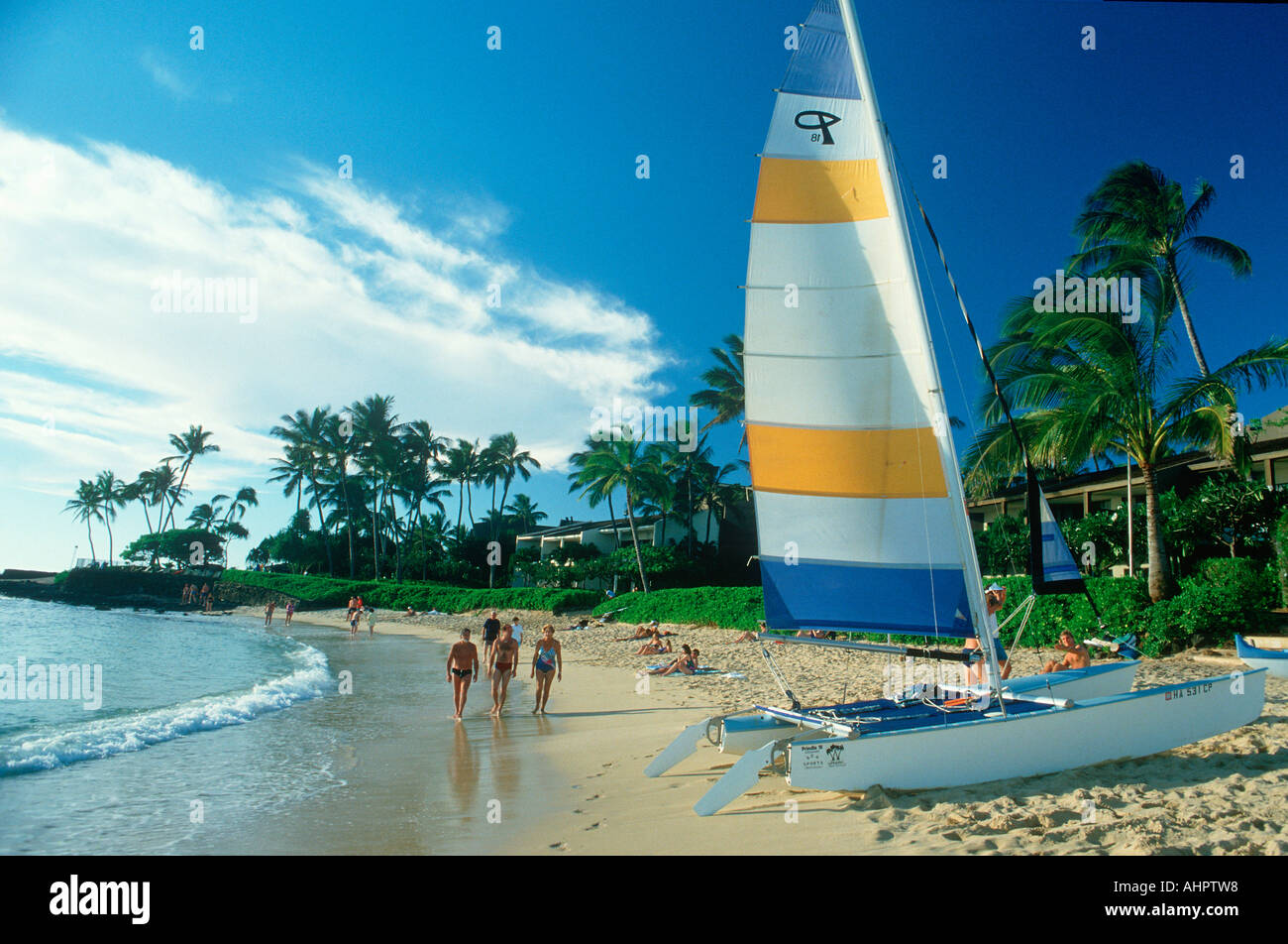 Tourists walking on the beach at a resort hotel on Hanapepe Bay in Kauai Hawaii Stock Photo