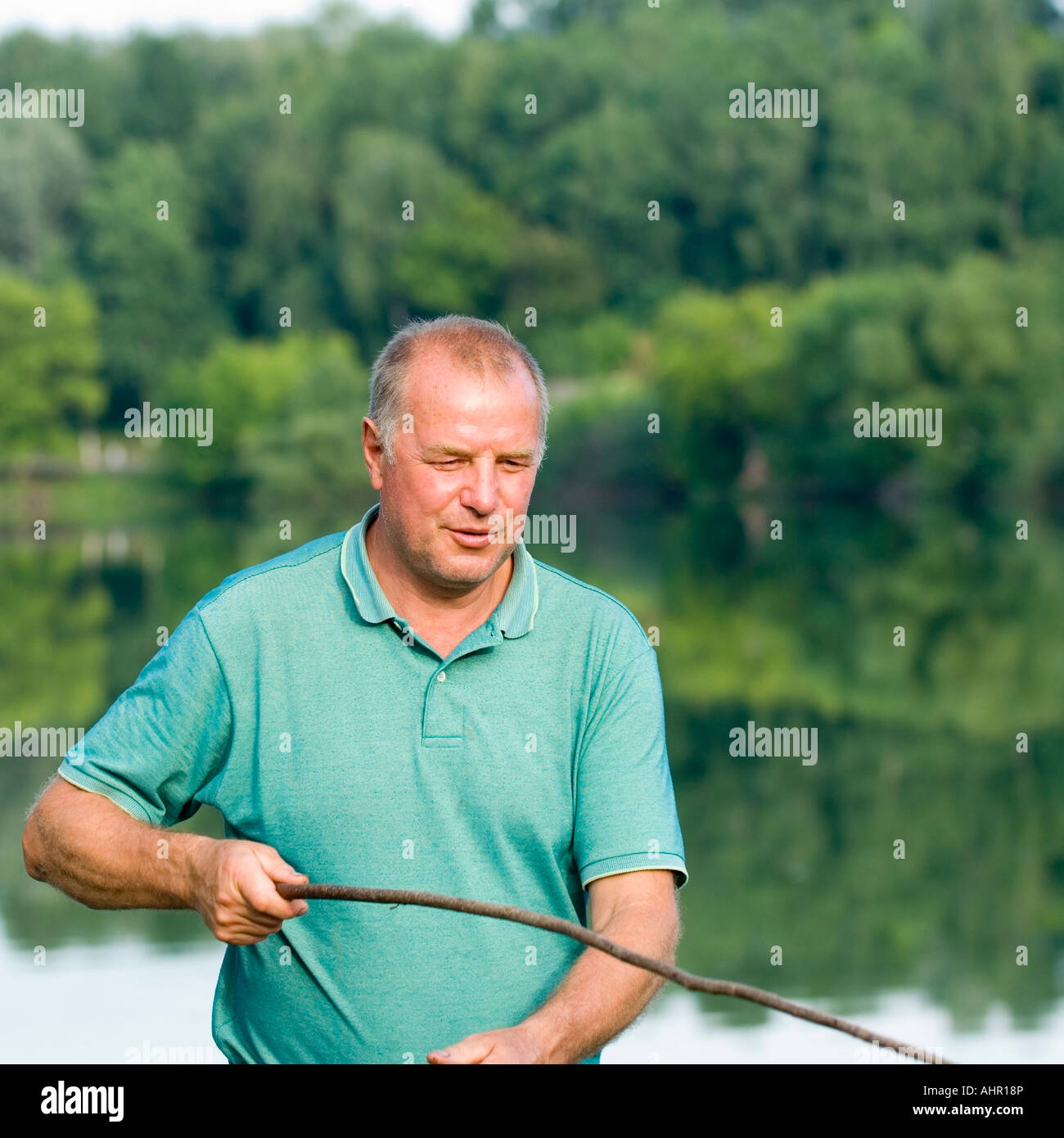 Middle aged man is fishing on the Lake in Ukraine Eastern Europe Stock Photo