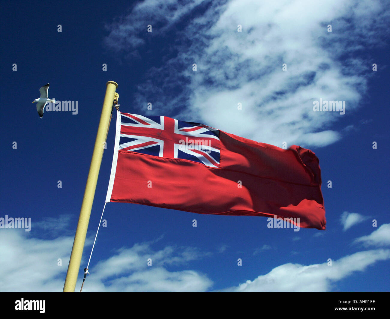 British red ensign nautical flag flying against a deep blue sky with