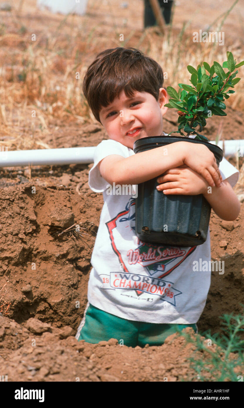 Latino boy planting a seedling on Earth Day Los Angeles California Stock Photo