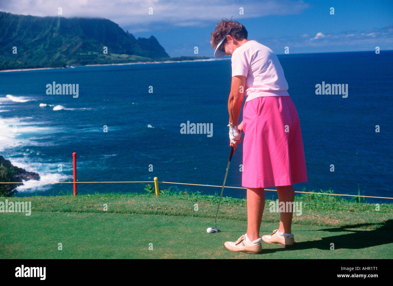 Female golfer putting in Kauai Hawaii Stock Photo