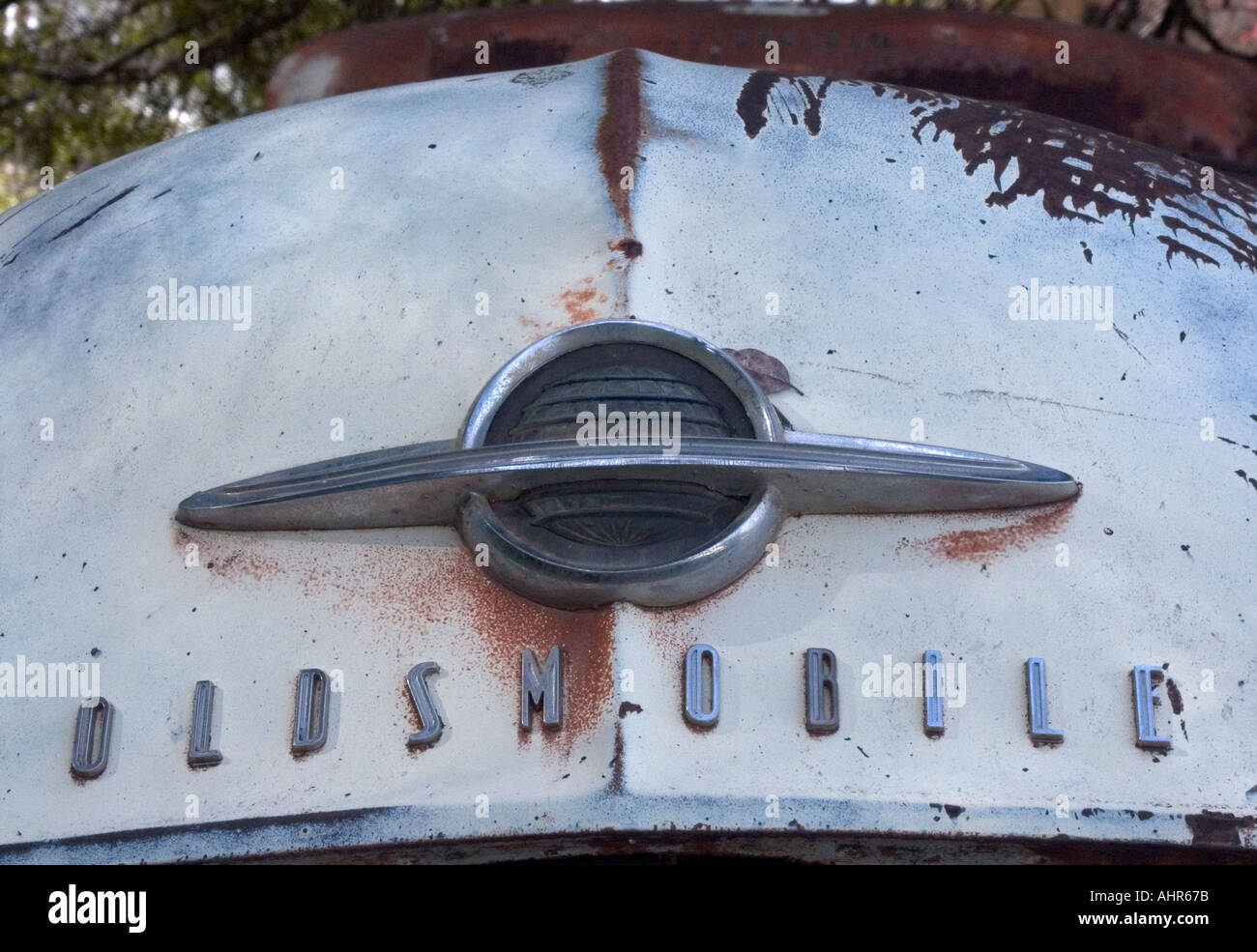 Rusty abandoned old Oldsmobile detail of logo on hood Stock Photo