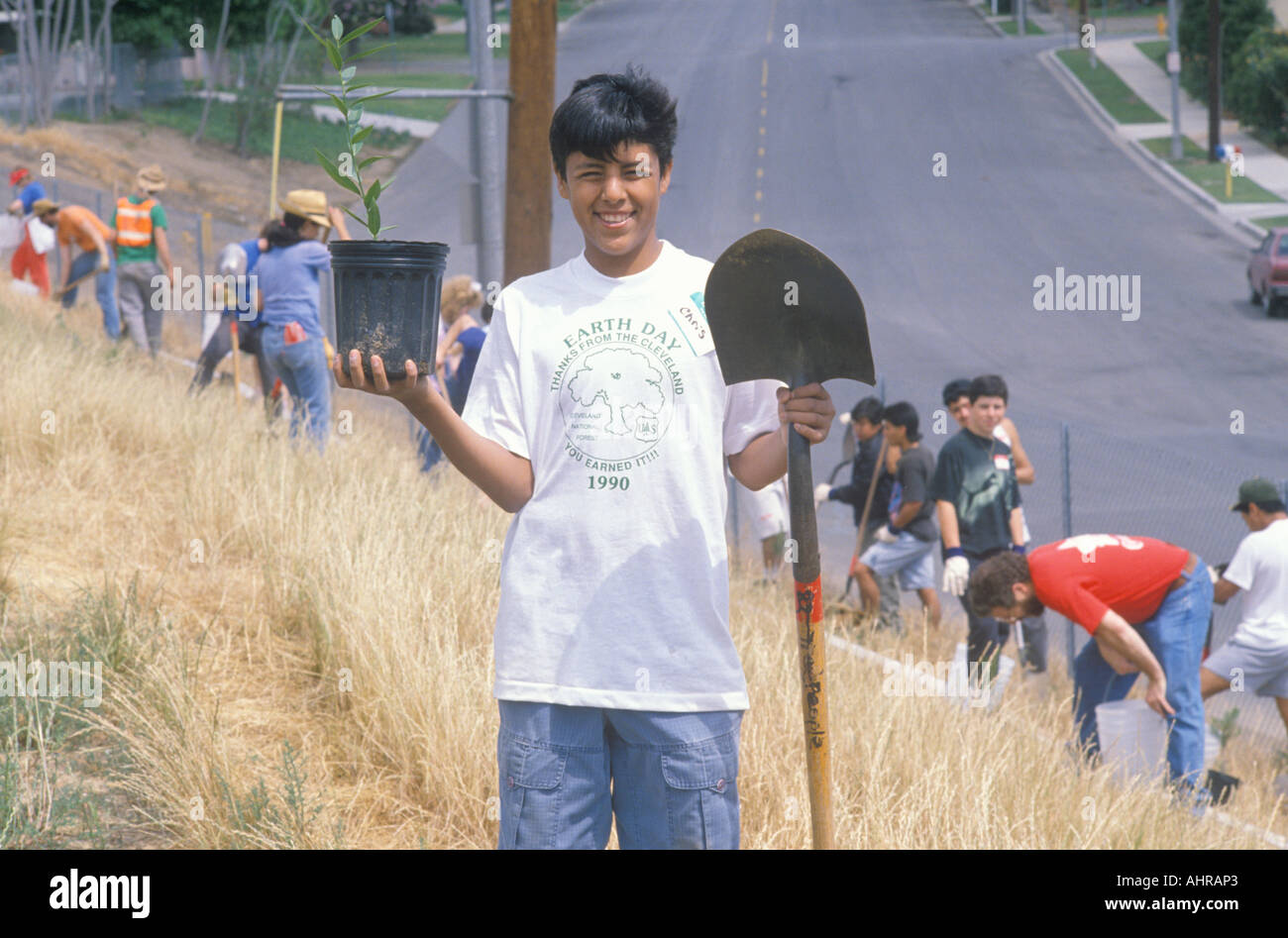 A boy wearing an Earth Day t shirt participating in a tree planting by the Clean Green volunteers of the Los Angeles Stock Photo