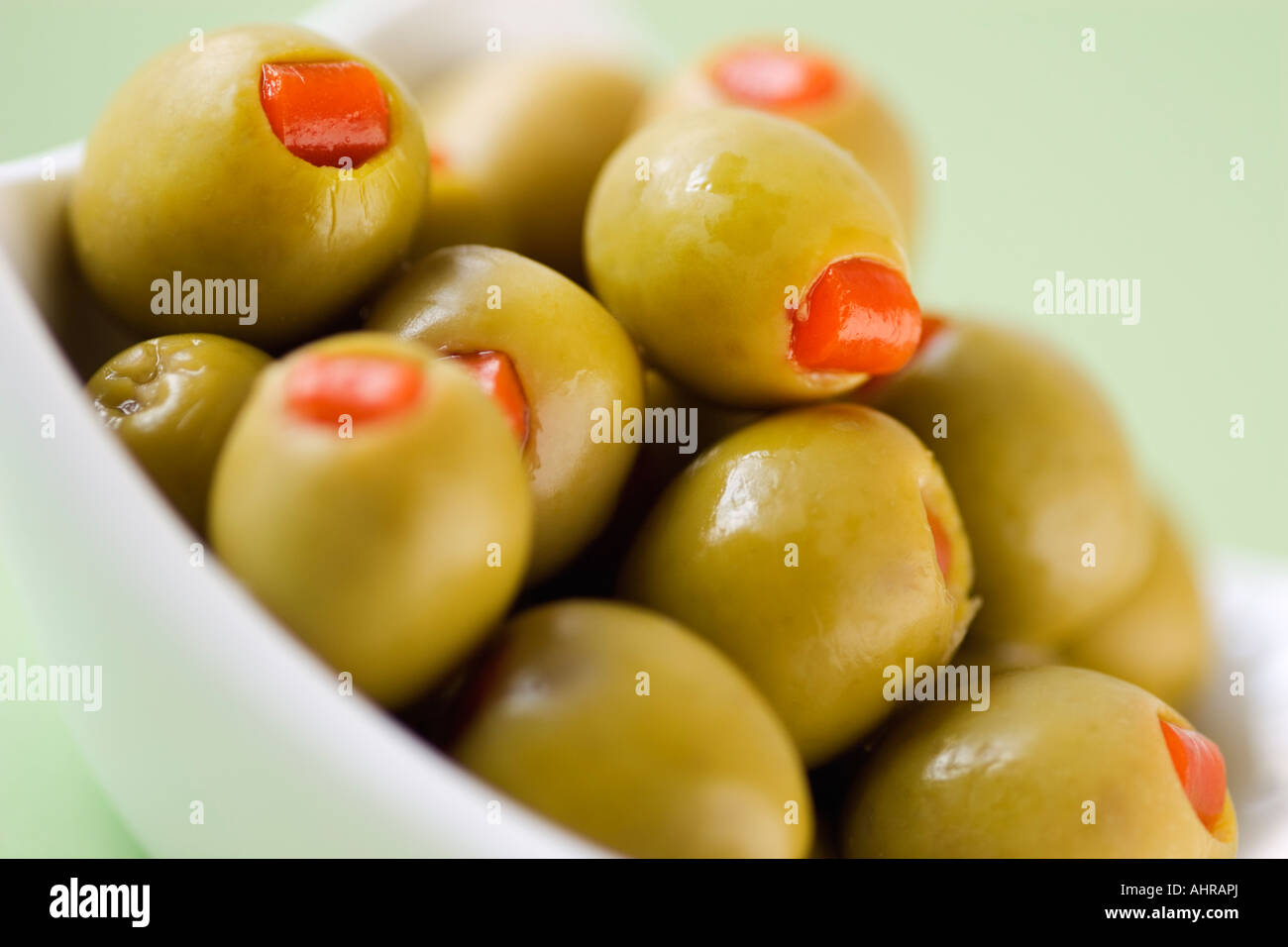 Green olives in white bowl close-up Food still life Stock Photo
