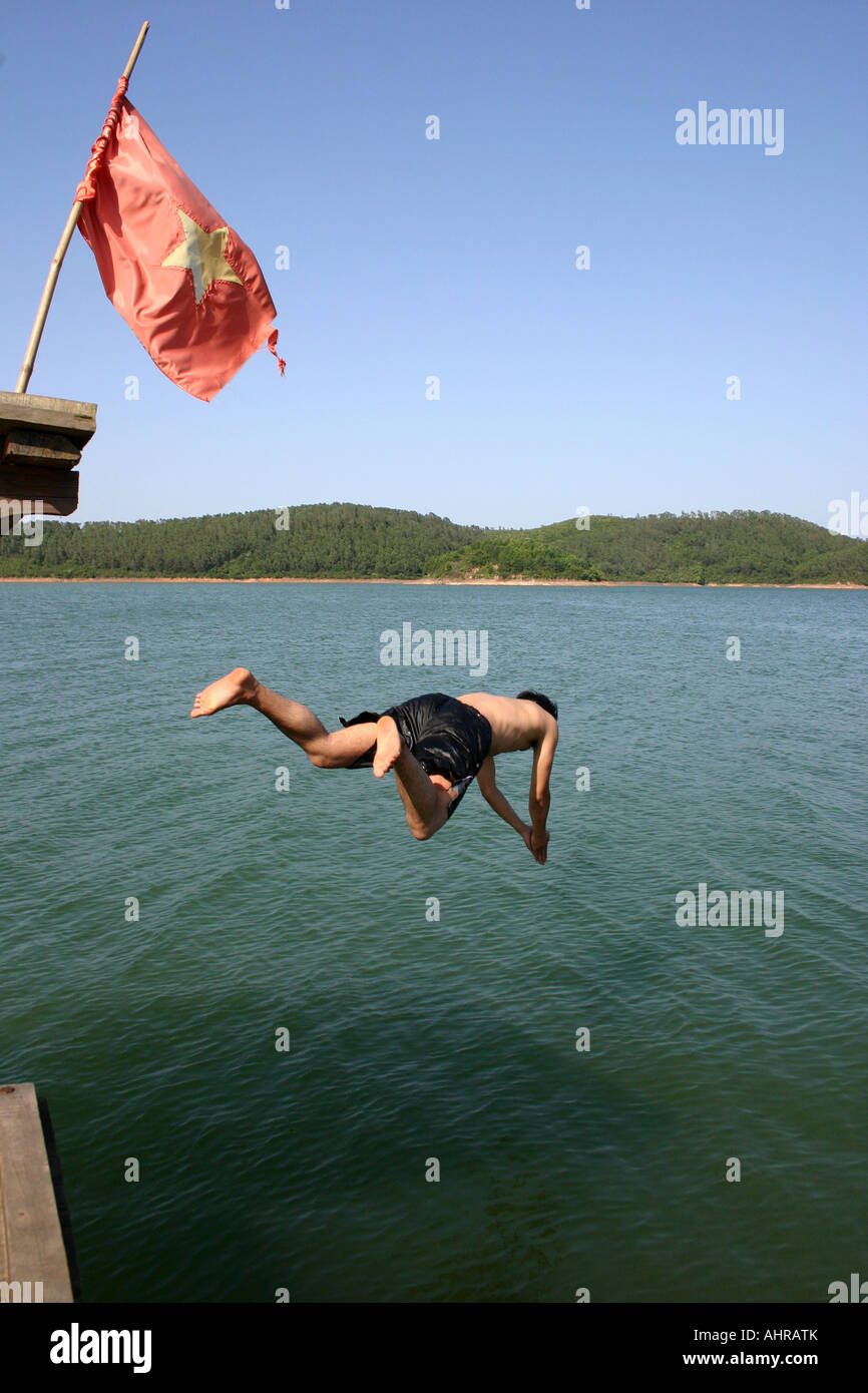 Vietnamese man diving off boat into lake Stock Photo Alamy