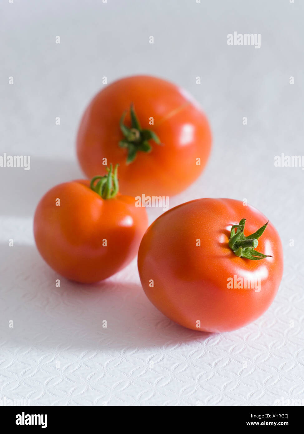 Three Red Tomatoes on a White Background Stock Photo