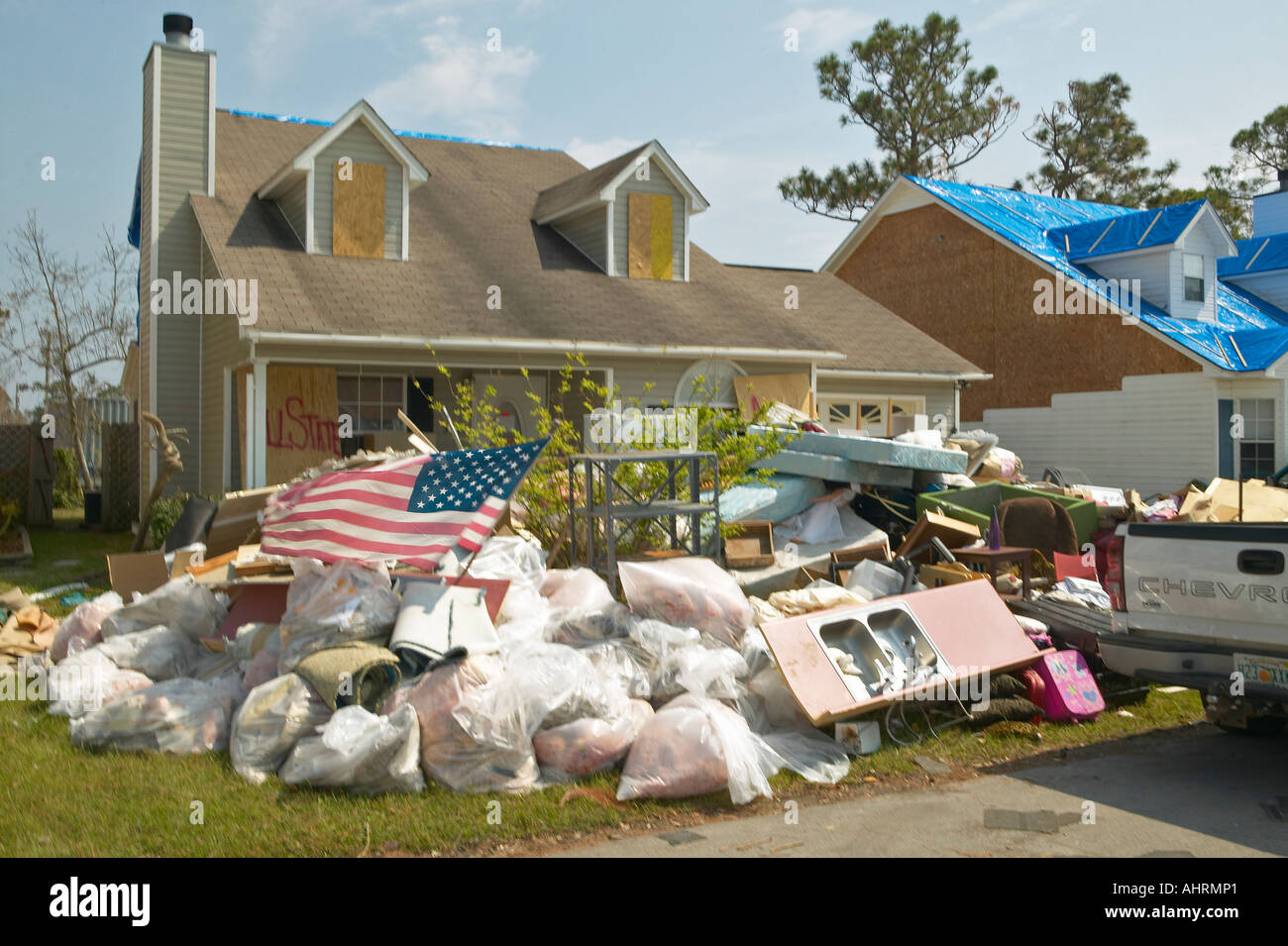 American flag and debris in front of house heavily hit by Hurricane ...