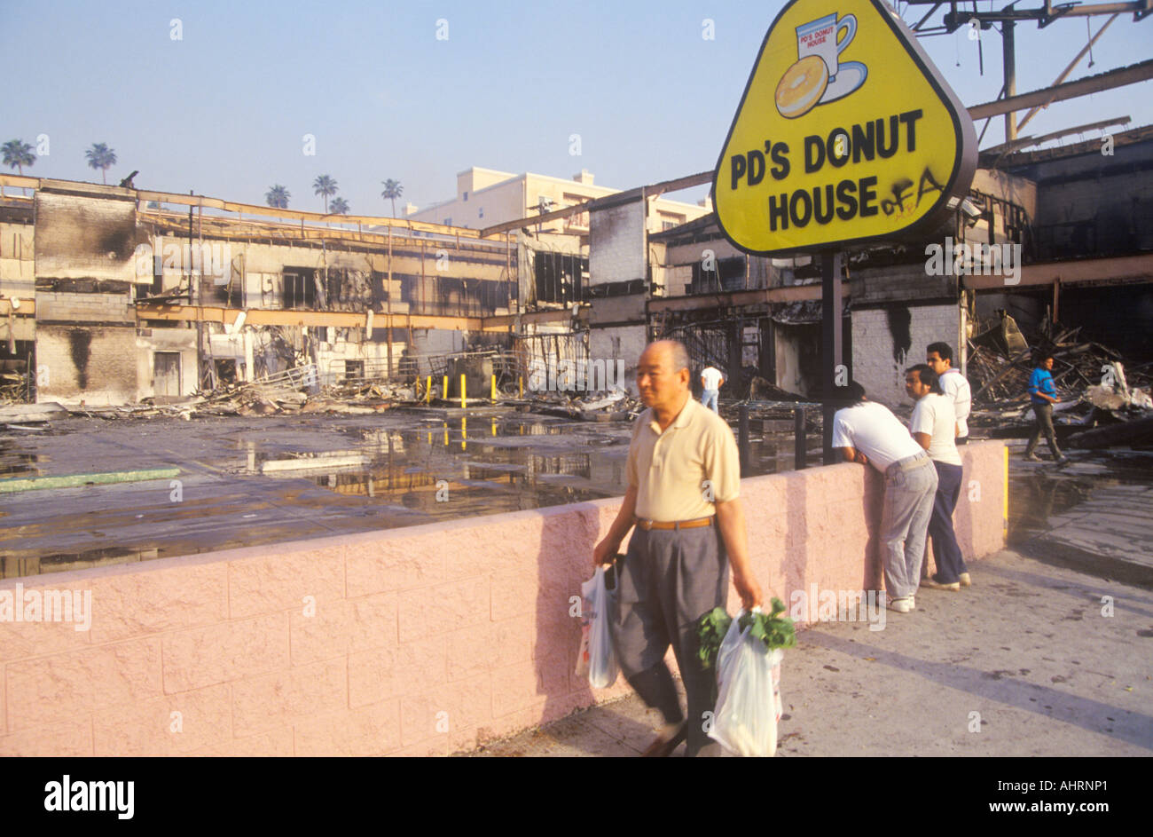 Man walking past donut shop destroyed during 1992 riots South Central Los Angeles California Stock Photo