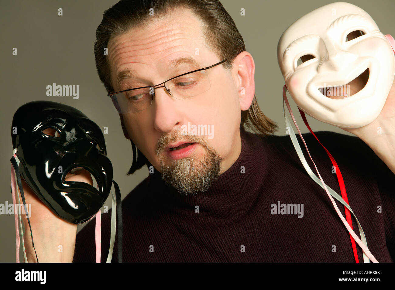 Man holding happy and sad mask Stock Photo