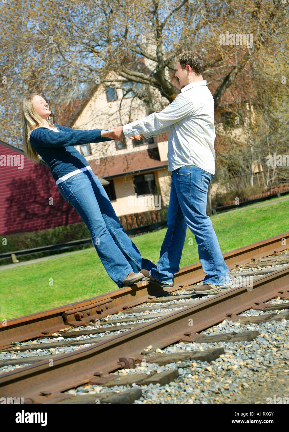 Couple holding hands on railroad track Stock Photo