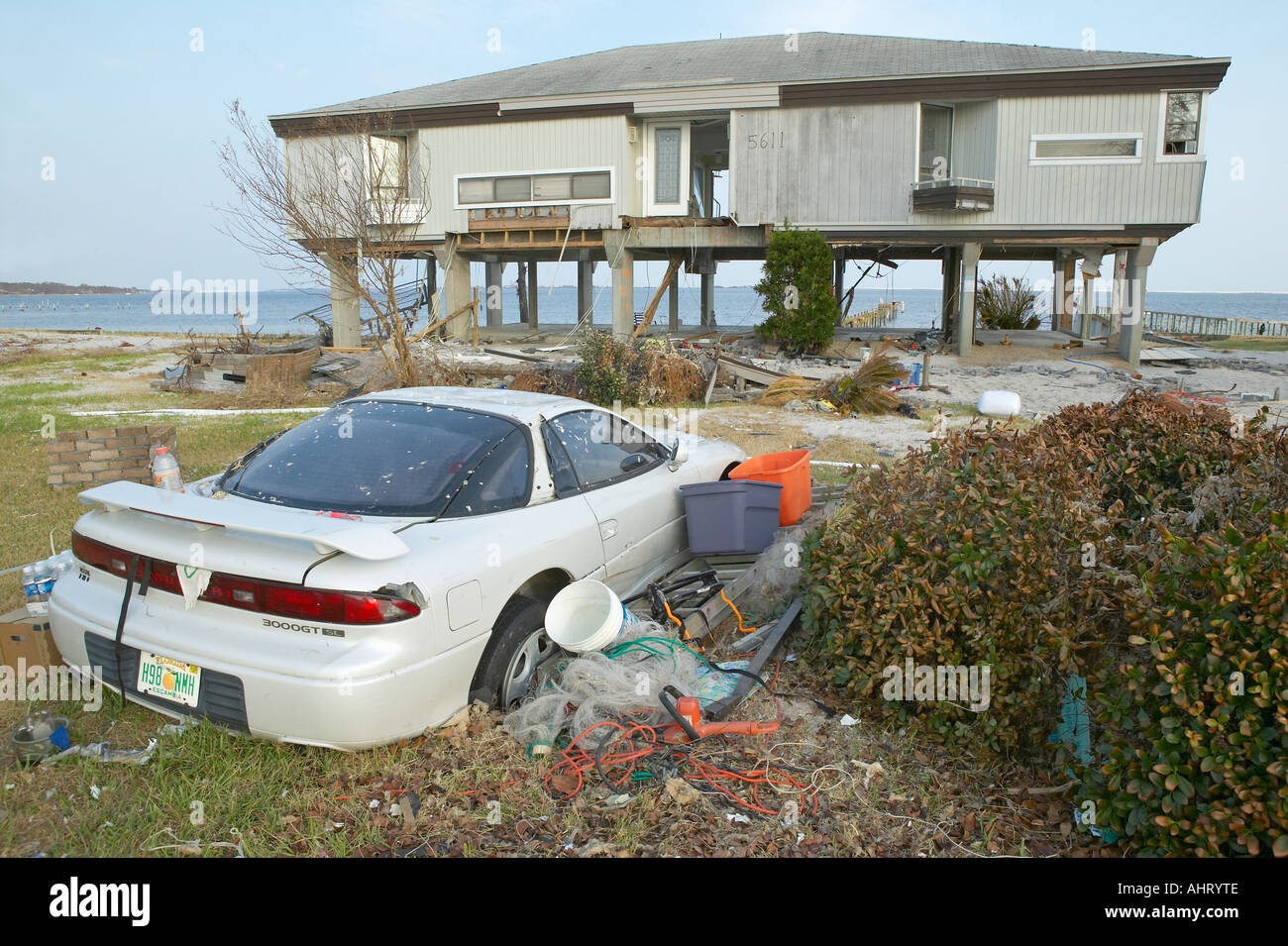 Wrecked car and debris in front of house heavily hit by Hurricane Ivan ...