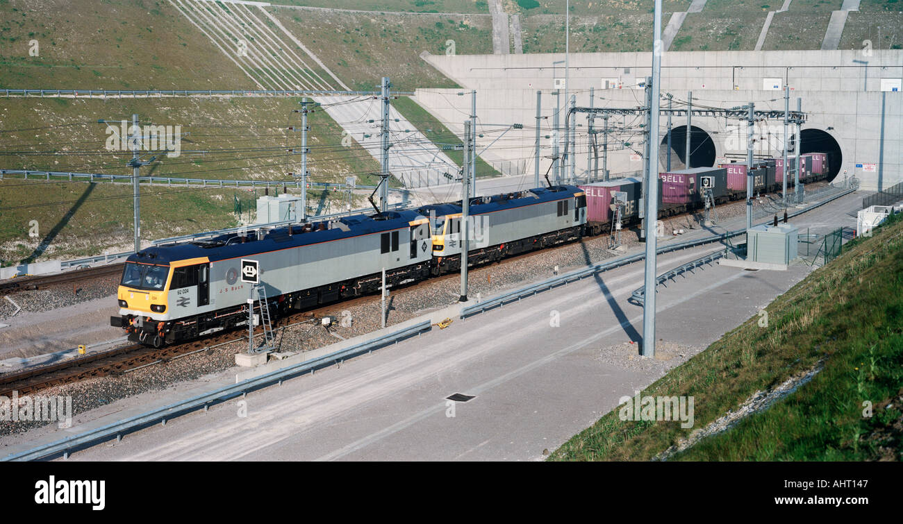 Two Eurotunnel Class 92 locomotives pulling freight wagons exit the French Portal after travelling through the Channel Tunnel. Stock Photo
