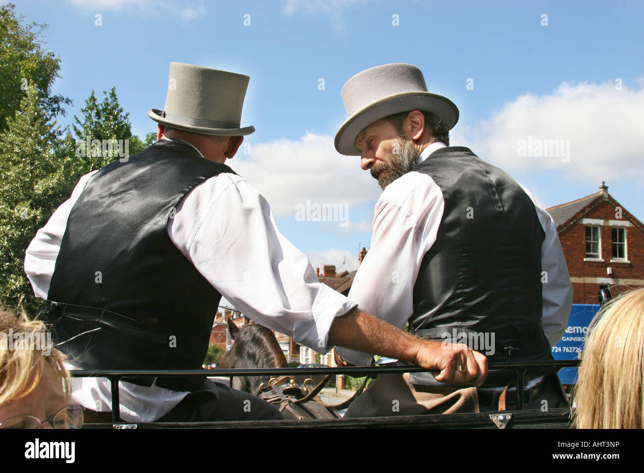 Driver and mate in top hat and tails on horse drawn open carriage