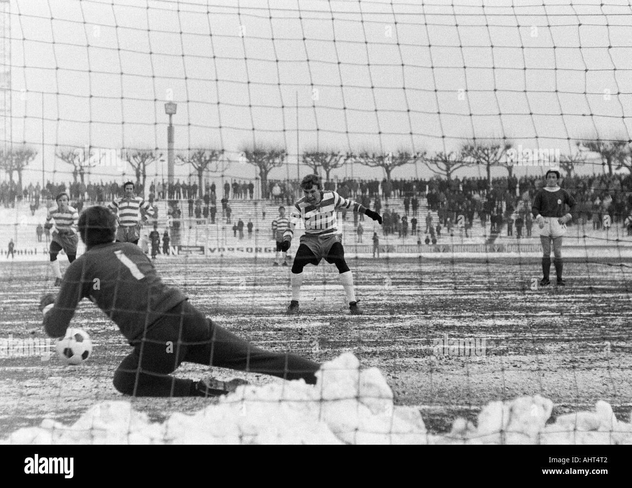 football, Bundesliga, 1970/1971, Wedau Stadium in Duisburg, MSV Duisburg versus Kickers Offenbach 2:2, game on snow ground, scene of the match, missed hand penalty to Duisburg, f.l.t.r. Rainer Budde (MSV), keeper Karlheinz Volz (OFC) saves the ball, Djord Stock Photo