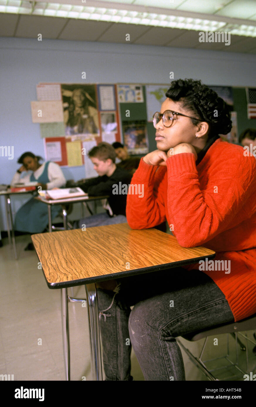 A black female 15 year old student wearing glasses in a day dreaming state of mind Stock Photo